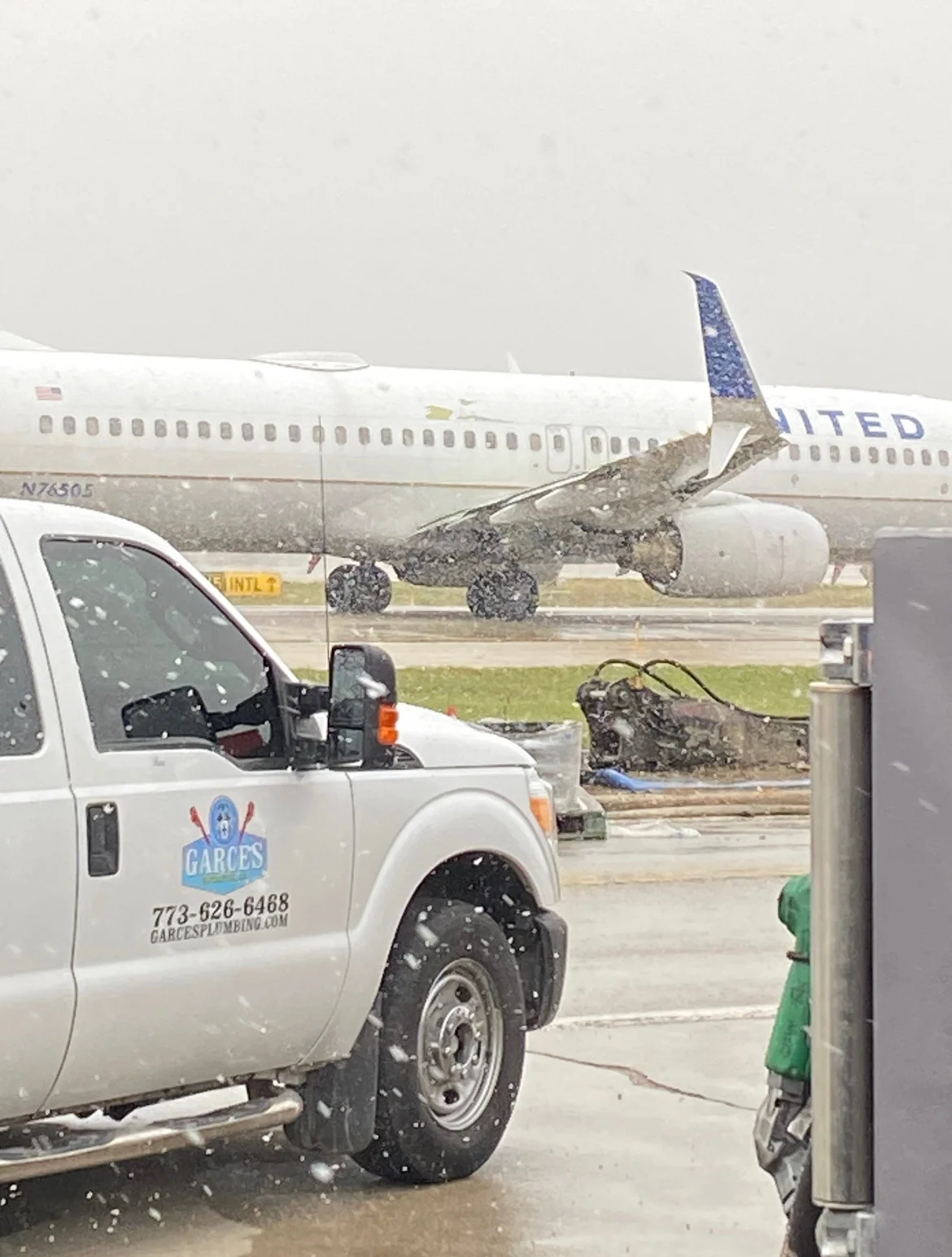 Garces Contractors service truck at O’Hare during snowfall with a United aircraft beyond